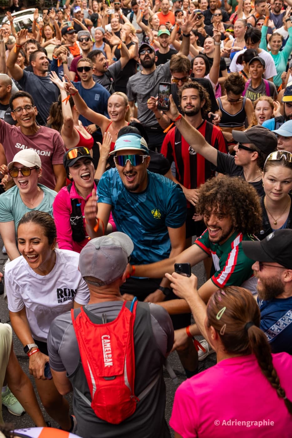 A crowd of runners cheering with their hands in the air