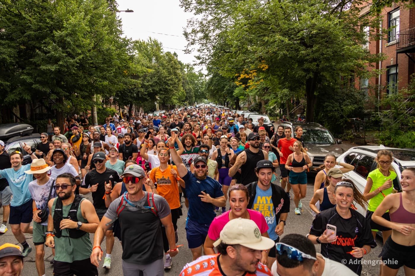 A large pack of runners filling a tree-lined Montreal street